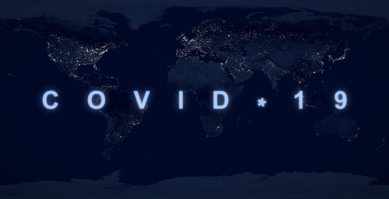 COVID-19 pandemic concept, name COVID on dark night planet map. World economy hit by coronavirus outbreak.